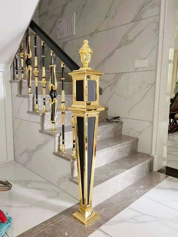 Gold finish newel post detail on staircase railing